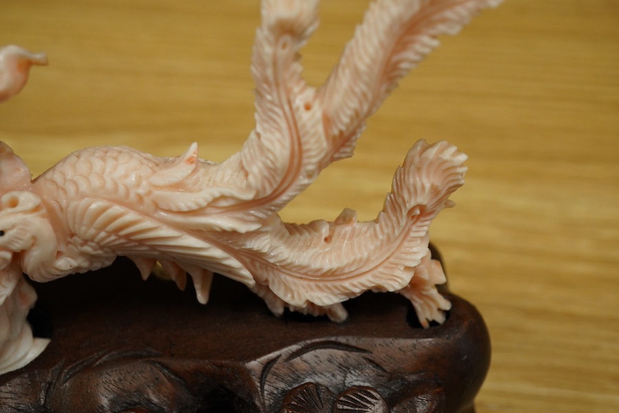 A Chinese coral group of a lady and a phoenix on carved hardwood base, 11cm high. Condition - good